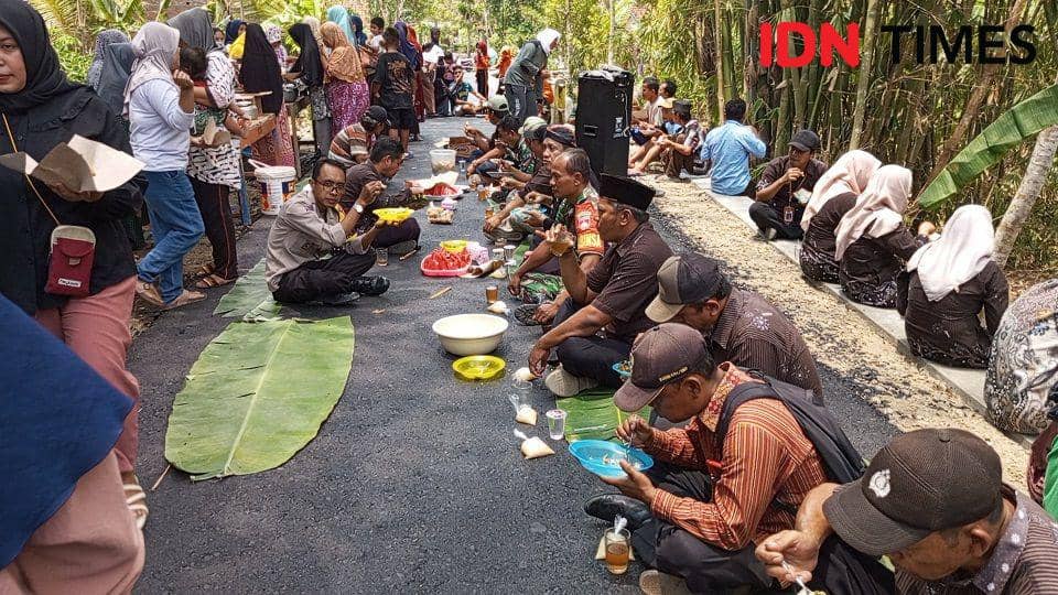 Usai didoakan para warga dan tokoh masyarakat setempat makan bersama di jalan yang baru selesai perbaikannya setelah 20 tahun, Kamis (9/11/2023).(IDN Times/Sutrisno)