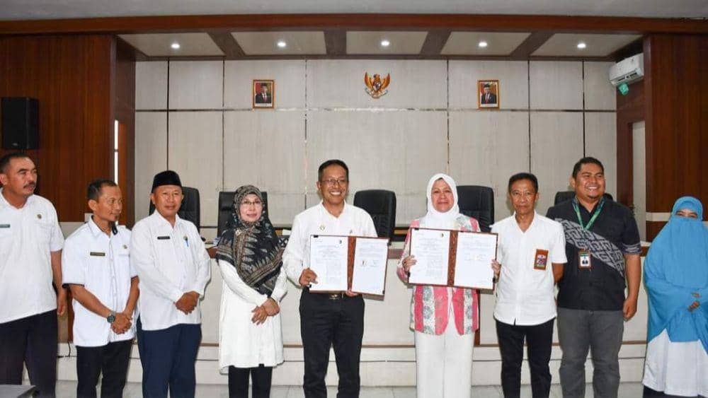 Pj. Bupati Lotim, M Juaini Taofik dan direktur Bank NTB Syariah menunjukkan dokumen mou kartu kredit pemerintah (dok. Humas Protokol Pemkab Lotim)
