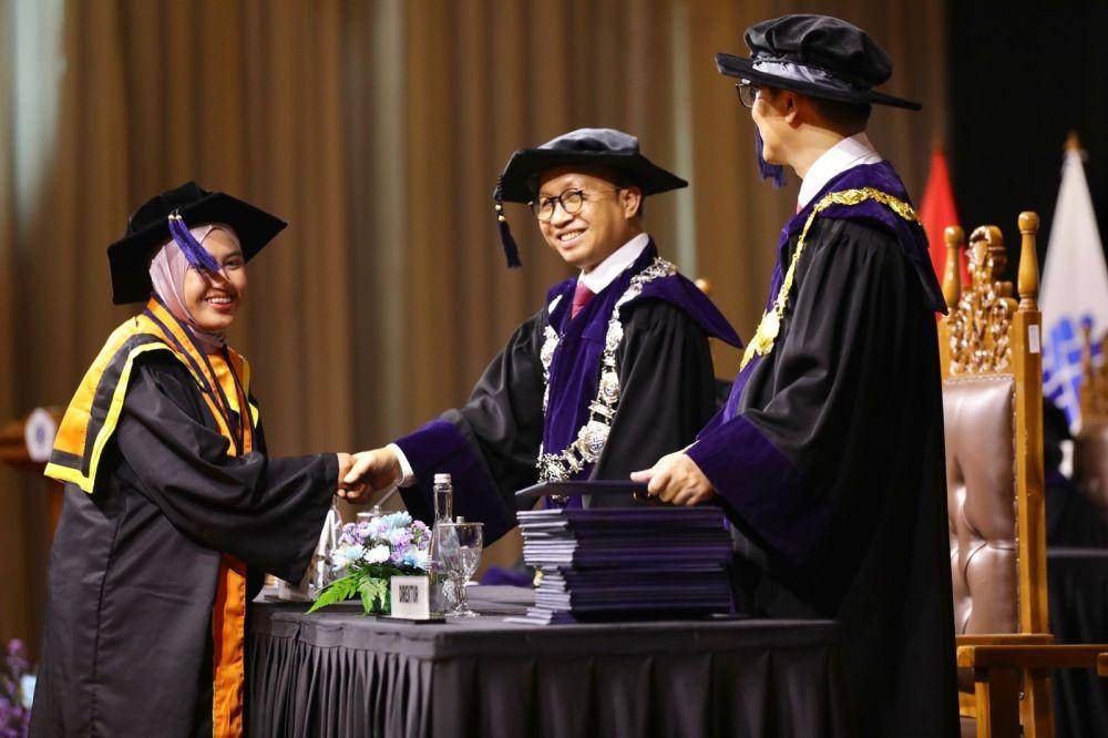 Sekretaris Jenderal Kementerian Ketenagakerjaan Anwar Sanusi menyalami salah satu wisudawan Polteknaker. (Dok. Kemnaker)