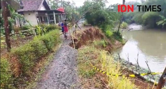 Jalan dipinggir Kalireja yang biasa dilalui oleh warga kini tidak bisa dilintasi motorn bahkan pejalan kaki pun diminta berhat hati akibat adanya rekahan tanah.(IDN Times/Sujatmiko)