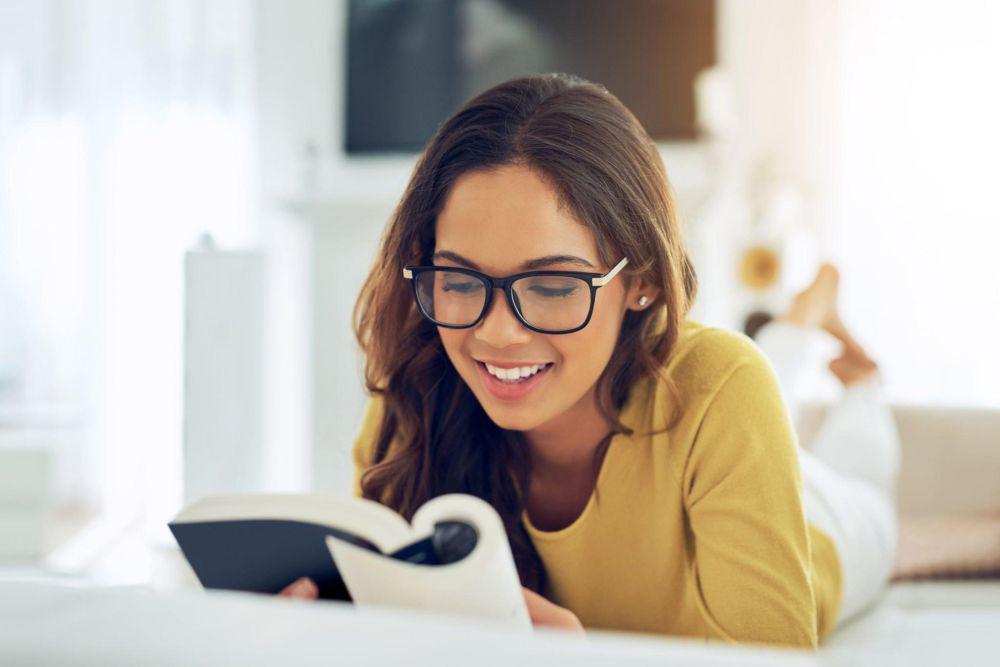 ilustrasi seorang wanita bahagia saat membaca buku (istockphoto.com/PeopleImages)