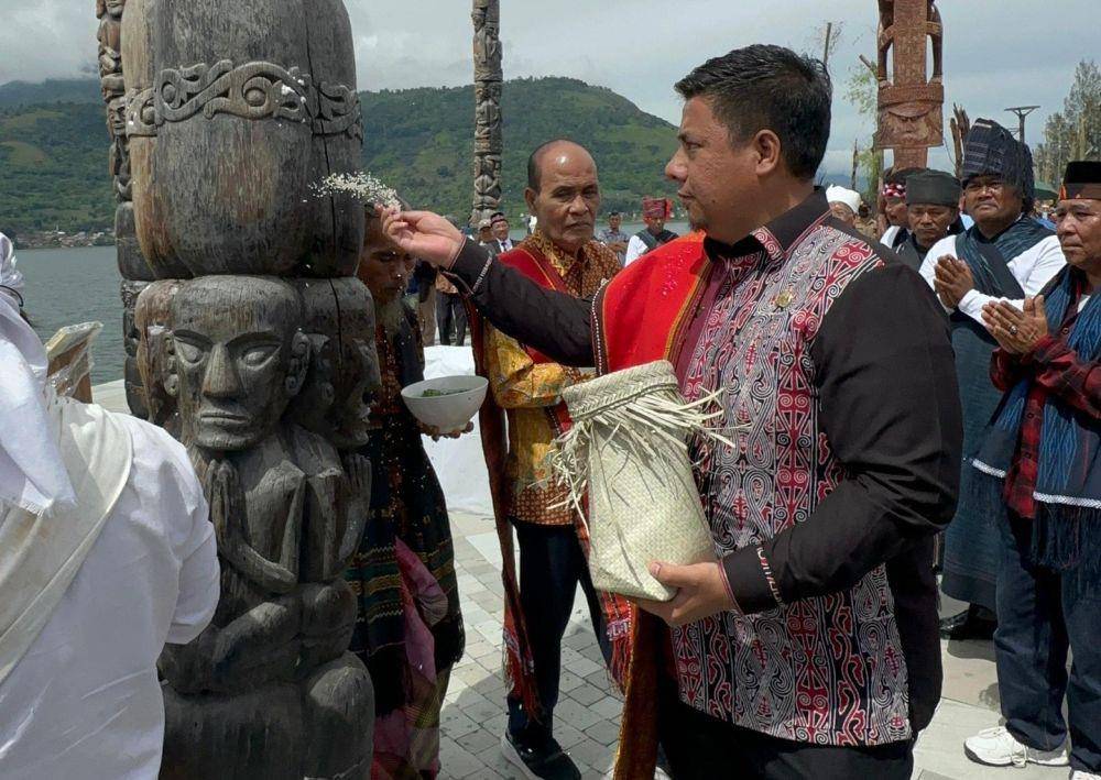Bupati Samosir Vandiko T. Gultom saat peresmian totem Batak secara adat di Pelataran Totem Dunia, Samosir, dan dilanjutkan dengan peresmian totem Suku Kamoro dari Papua. (dok. PTFI)