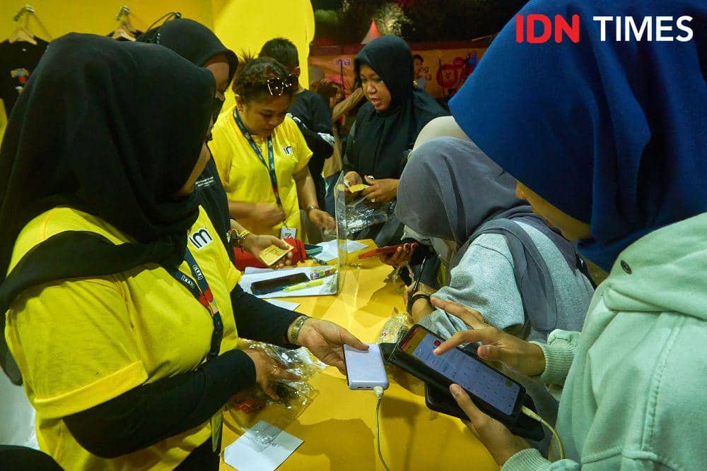 Sejumlah pengunjung melakukan registrasi IM3 Apps di booth IM3 yang ada di venue konser Collabonation Tour IM3 di Brebes, Kamis (23/11/2023). (IDN Times/Dhana Kencana)