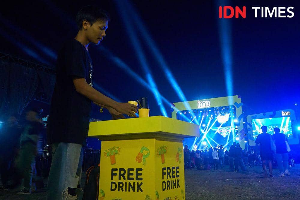 Penonton menuang air untuk minum di layanan free dring yang tersedia di venue konser Collabonation Tour IM3 di Brebes, Kamis (23/11/2023). (IDN Times/Dhana Kencana)