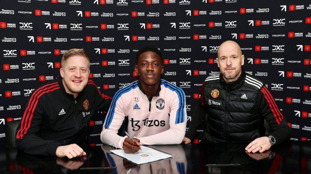 Kobbie Mainoo (tengah) saat menandatangani kontrak profesional bersama Manchester United. (twitter.com/ManUtd)