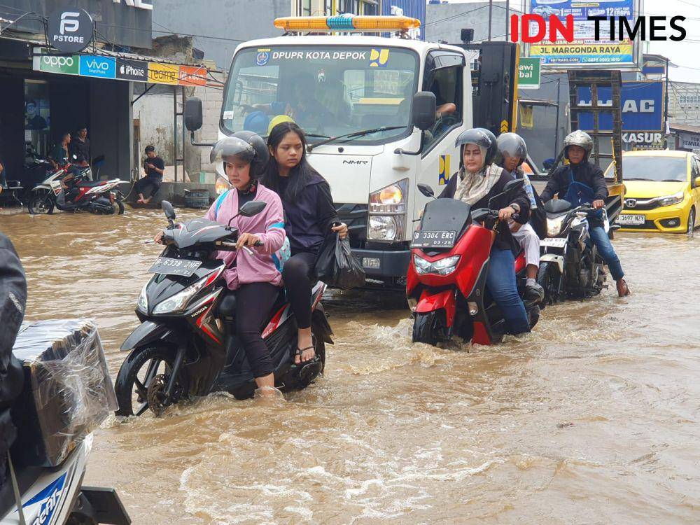 Sejumlah pengendara melintas di lokasi banjir Jalan Pramuka, Pancoranmas, Kota Depok. (IDNTimes/Dicky)