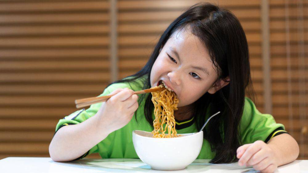 Seorang anak sedang makan mi instan dengan sumpit (klikdokter.com)