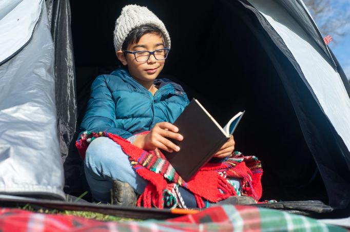 ilustrasi anak sedang camping sambil membaca buku (pexels.com/kampus)