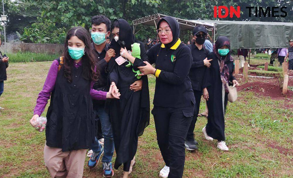 Ibu korban bersama keluarga serta didampingin kepolisian saat ikut memakamkan ke empat anaknya di TPU Bedahan, Sawangan, Kota Depok. (IDNTimes/Dicky)