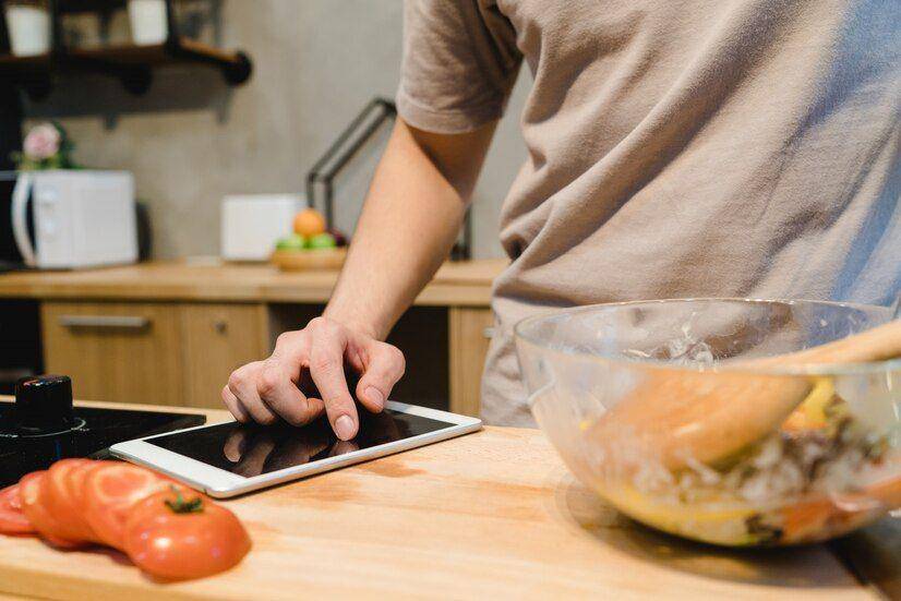 Ilustrasi memasak sambil mencari resep di internet (Freepik.com/tirachardz)