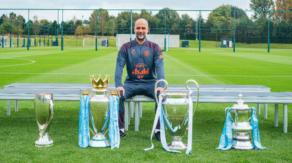 Pep Guardiola berpose bersama trofi yang ia raih pada musim 2022/2023. (twitter.com/ManCity)