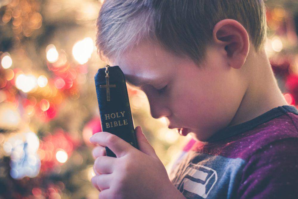 Ilustrasi seorang anak berdoa di hari Natal (unsplash.com/@davidbeale)