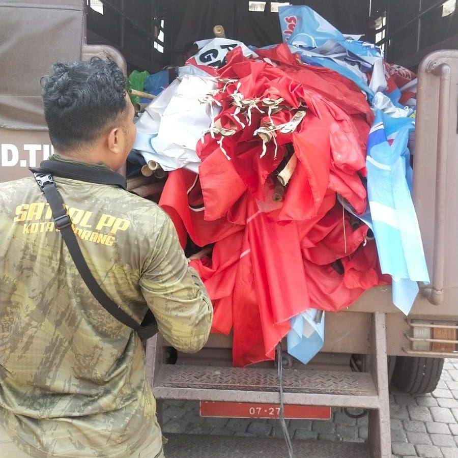 Seorang petugas Satpol PP Kota Semarang tampak memasukan bendera partai politik (parpol) ke dalam truk rantib dalam rangka menertibkan alat peraga kampanye yang melanggar aturan. (IDN Times/Dok Humas Bawaslu Kota Semarang)