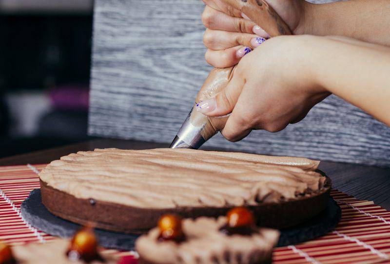 gambar orang mendekorasi kue (unsplash.com/Leonardo Cirimbelli)