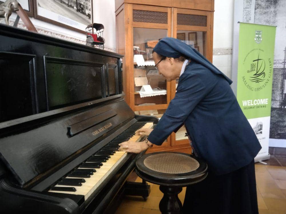 Lucia Anggraini memainkan piano produksi Jerman tahun 1875 milik Sekolah Katolik Cor Jesu Malang. (IDN Times/Rizal Adhi Pratama)