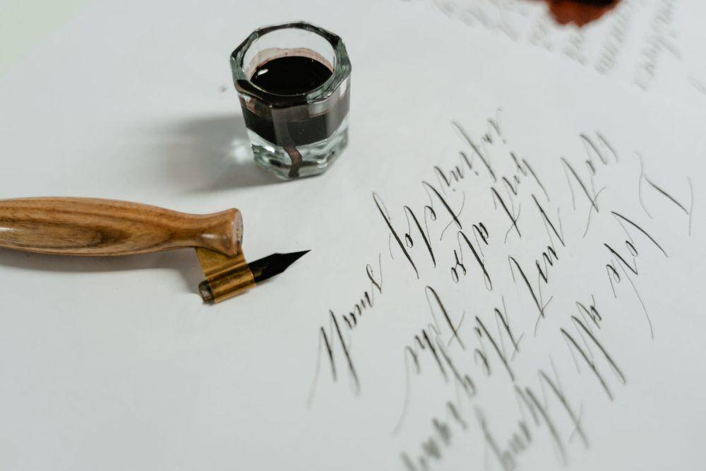 ilustrasi pena dan tinta hitam di atas kertas (pexels.com/@mart-production)