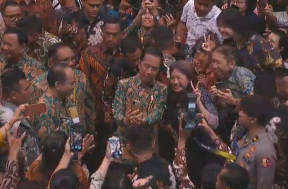 Para jemaat peserta perayaan natal nasional di Surabaya berebut berfoto dengan Presiden Jokowi. Beberapa mengacungkan pose dua jari. (IDN Times/Capture Youtube Kemenkominfo RI).