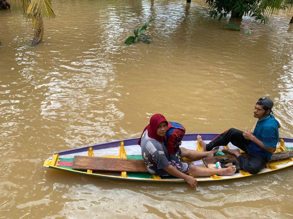 Warga saat diatas sampan untuk menuju ke tempat pengungsian (IDN Times/ Fanny Rizano)