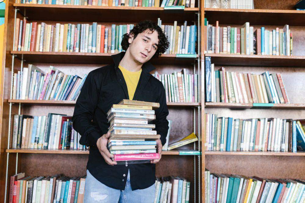 ilustrasi lelaki yang sedang membawa tumpukan buku (pexels.com/RDNE Stock project)