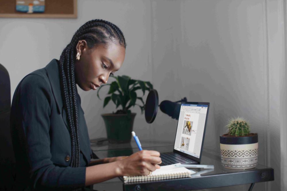 potret seorang wanita bekerja di depan laptop dan menulis (unsplash.com/Surface)