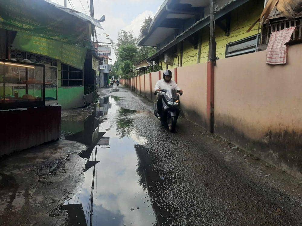 Jalan rusak sebabkan genangan air hujan di Banjarmasin.