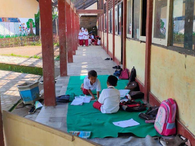 Siswa saat belajar di teras gedung sekolah (IDN Times /Ruhaili)