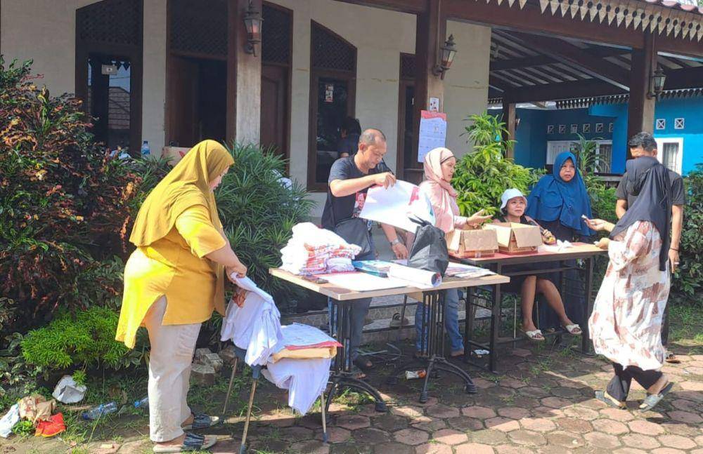Sejumlah relawan memberikan sejumlah atribut pasangan capres dan cawapres Ganjar-Mahfud di Sukmajaya, Kota Depok.  (Dokumen GMCD)