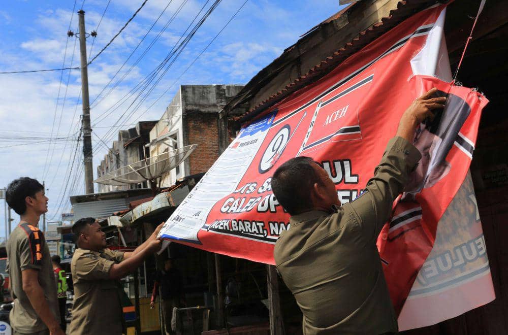 Petugas gabungan dari panitia pengawasan pemilihan (Panwaslih), TNI/Polri dan Satpol PP mencopot alat peraga kampanye (APK) saat penertiban di jalan protokol Meulaboh, Aceh Barat, Aceh, Senin (25/12/2023). (ANTARA FOTO/Syifa Yulinnas)