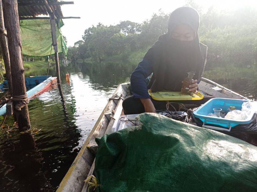 Seorang mahasiswi yang sedang meneliti sampel air gambut di Parit Nanas, Pontianak, Kalimantan Barat. (dok.pribadi/Tri Ainun Fadilla)