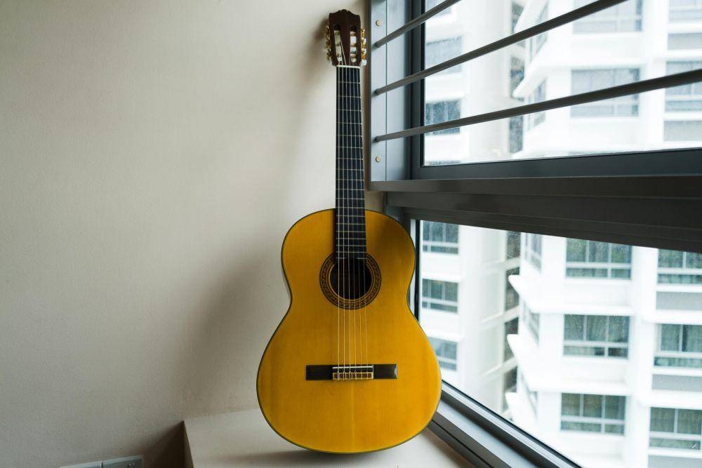 ilustrasi gitar yang diletakan dekat jendela (pexels.com/Azad Azahari)