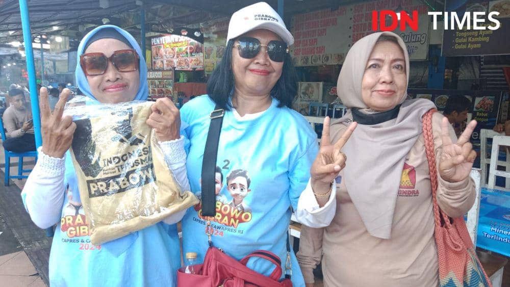 Mbah Asih menunjukkan kaos cokelat yang didapatkan saat ikut kampanye Prabowo-Gibran di Semarang bersama rekannya Wahyu Pancawati dan seorang timsesnya. (IDN Times/Fariz Fardianto)