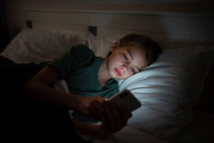 ilustrasi anak laki-laki bermain smartphone di tempat tidur (freepik.com/freepik)