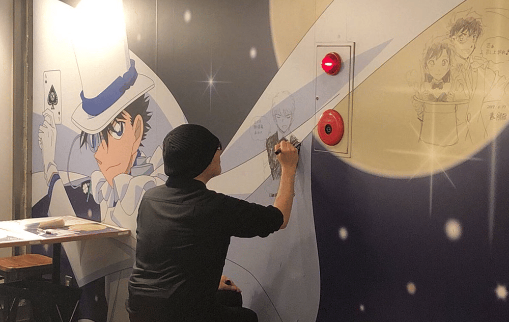 Gosho saat membuat ilustrasi di Kaito Kid Cafe (detectiveconanworld.com)