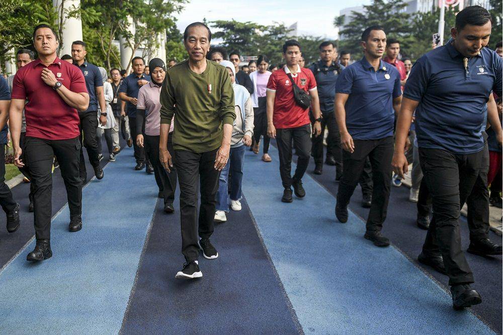 Presiden Joko Widodo menyapa warga saat berjalan kaki di Lapangan Gasibu, Bandung, Jawa Barat, Minggu (4/2/2024). Presiden Joko Widodo ditemani keluarga melakukan jalan santai di tempat itu. (ANTARA FOTO/Hafidz Mubarak A)