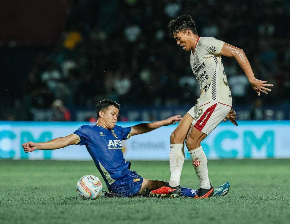 Pemain Bali United (kanan) sedang berebut bola dengan pemain Persik Kediri (kiri). (Instagram.com/baliunitedfc)