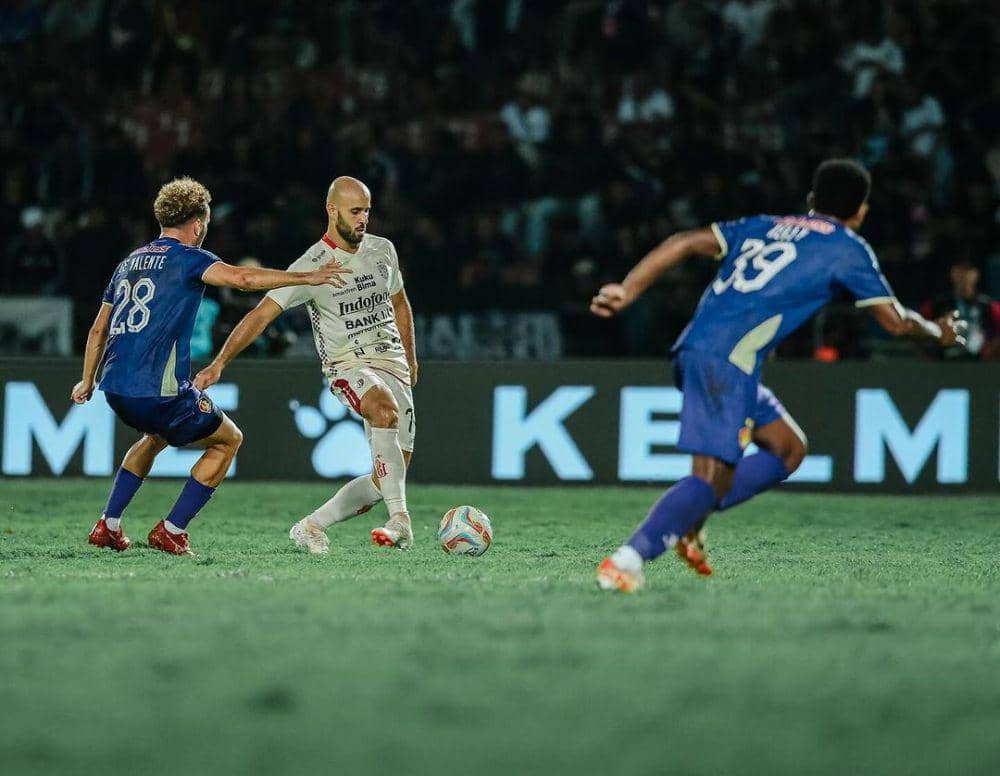 Pemain Bali United, Mohammed Rashid (putih) sedang berebut bola dengan pemain Persik Kediri (biru). (Instagram.com/baliunitedfc)