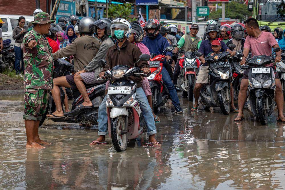 Prajurit TNI mengarahkan pengendara untuk memutar balik karena jalur utama jalan Semarang-Purwodadi tergenang banjir di Kecamatan Gubug, Grobogan, Jawa Tengah, Selasa (6/2/2024). (Antara/Aji Styawan)