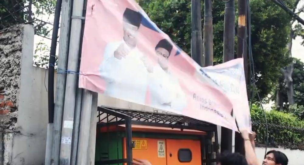 Aksi mahasiswa dalam demo 7 Februari 2024 ikut mencopot baliho paslon AMIN di Jalan Harmoni. (Dokumentasi Sorgemagz)