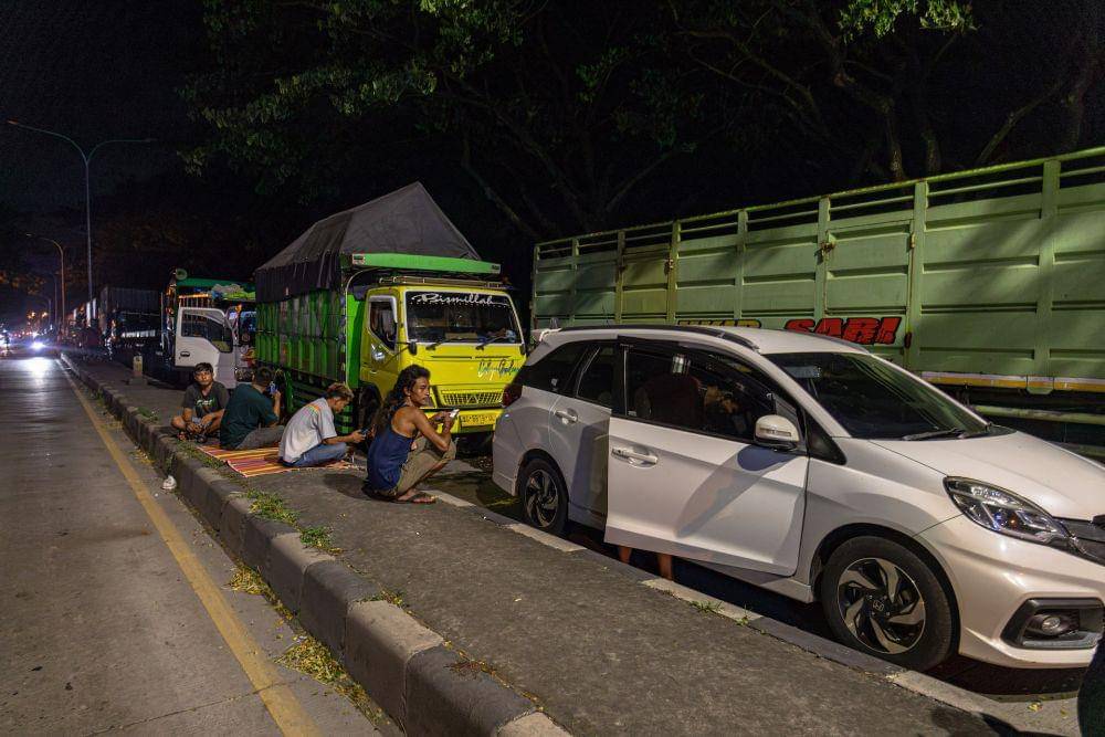 Sejumlah pengendara truk maupun mobil pribadi beristirahat dan memarkirkan kendaraan mereka di jalan raya karena jalur Pantura Semarang-Kudus terendam banjir di Kecamatan Karanganyar, Kabupaten Demak, Jawa Tengah, Kamis (8/2/2024) malam. (ANTARA FOTO/Aji Styawan)
