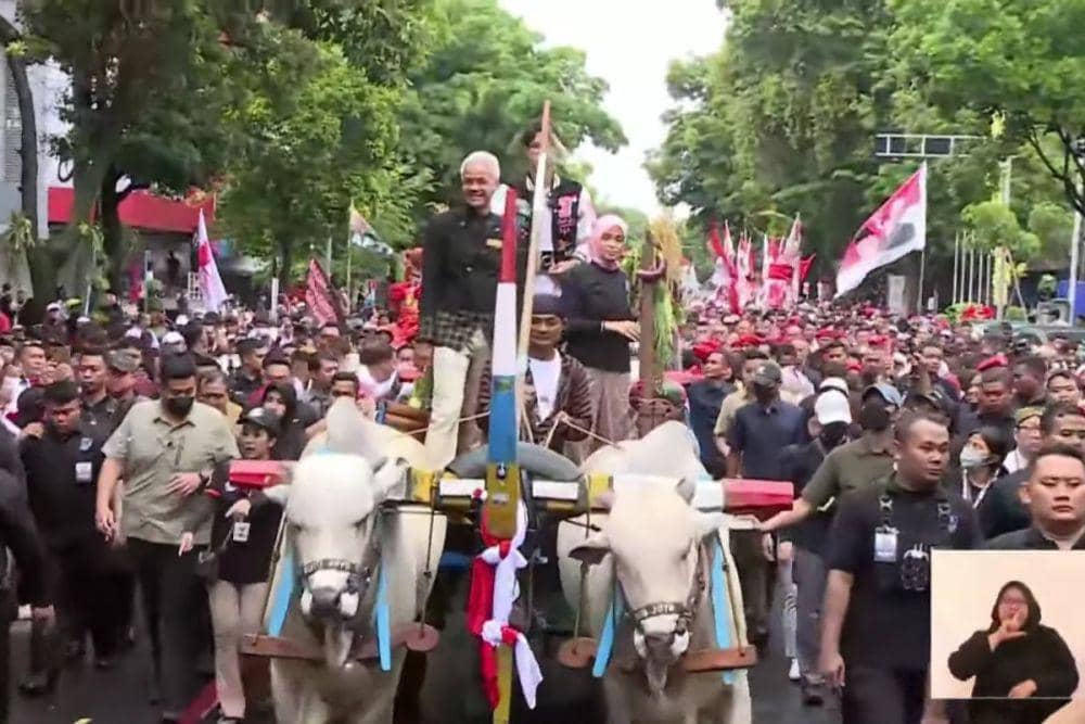 Ganjar dan Mahfud menaiki sapi saat iring-iringan dalam acara Hajatan Rakyat di Solo untuk dukung Ganjar - Mahfud di Solo pada Sabtu (10/2/2024). (youtube.com/PDI Perjuangan)