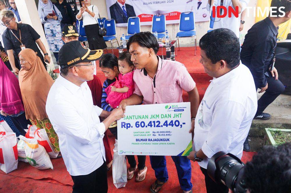 Menko PMK Muhadjir Effendy menyerahkan santuan BPJS Ketenagakerjaan di Belawan (Menko PMK Muhadjir Effendy menyerahkan santuan BPJS Ketenagakerjaan di Belawan (IDN Times/Doni Hermawan)