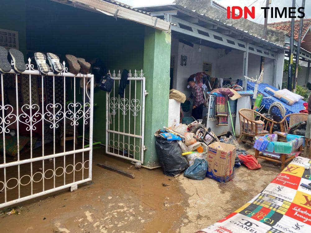 Warga Perumahan Gelora Persada, Kelurahan Rajabasa Jaya, Kecamatan Rajabasa, Bandar Lampung membersihkan perabotan, Minggu (25/2/2024). Perumahan ini salah satu titik terparah terdampak banjir terjadi kemarin. (IDN Times/Martin L Tobing).