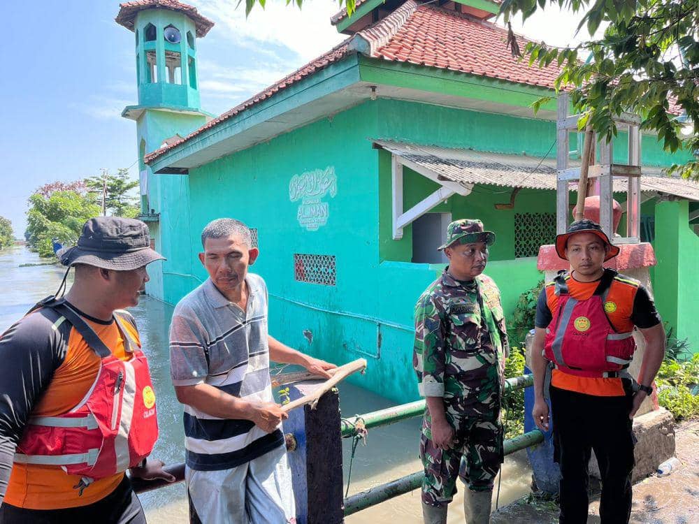 Warga bersama Koramil Brebes saat berjaga di jembatan untuk antisipasi dampak banjir. (IDN Times/Dok Humas Basarnas Cilacap)