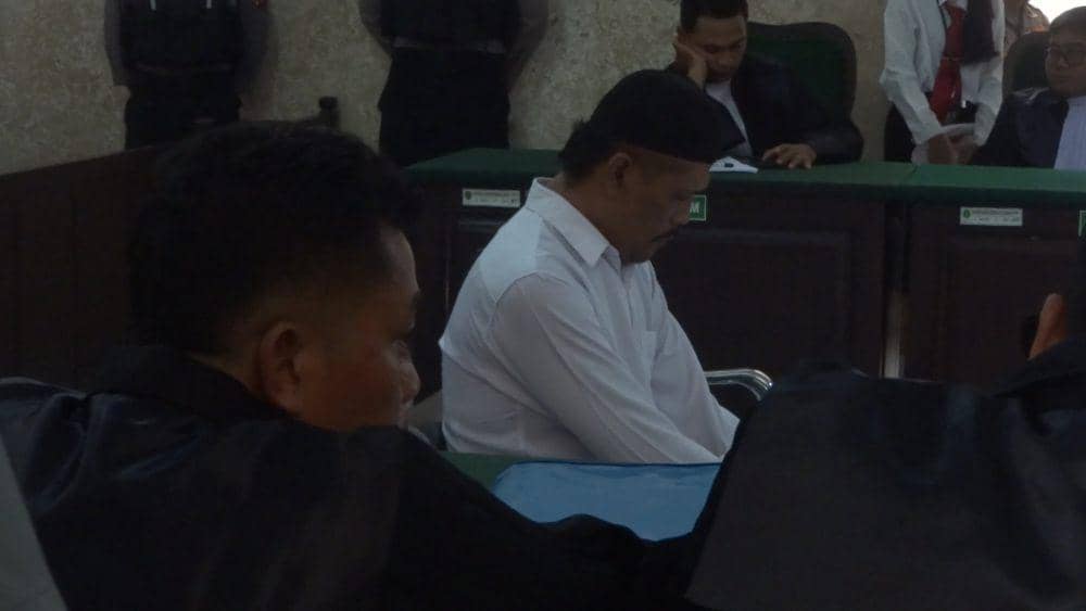 Terdakwa kasus pembunuhan pasutri di Tulungagung saat mengikuti sidang. IDN Times/ Bramanta Pamungkas