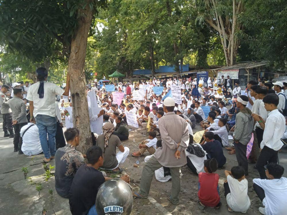 Ratusan jamaah terdakwa berkumpul didepan kantor Kejari Lotim (IDN Times/Ruhaili)