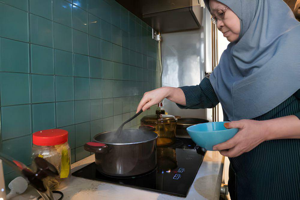 ilustrasi wanita mempersiapkan makanan untuk sahur (istockphoto.com/nattrass)