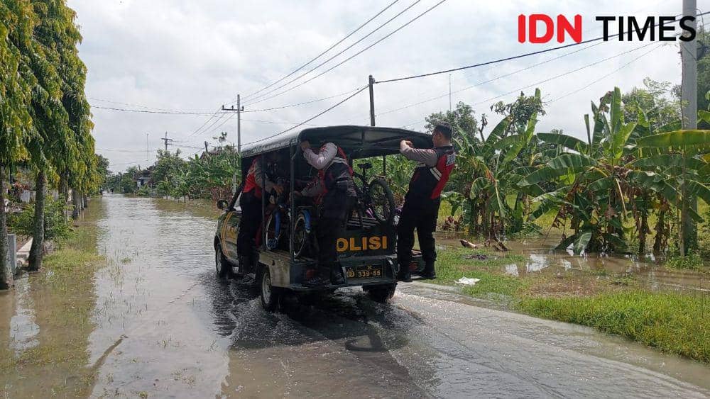 Polisi seberangkan siswa sekolah yang tidak berani seberangi banjir. IDN Times/ Riyanto