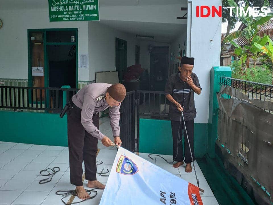 Dai Bhabinkamtibmas Bripka Rohmat Aziz saat akan pasang spanduk laramgan bunyikan petasan, Sabtu (9/3/2024).(IDN Times/Cokie Sutrisno)