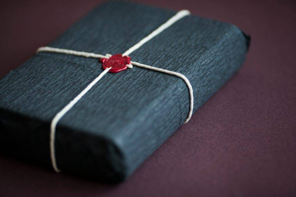 cap lilin merah pada buku biru (unsplash.com/Zoya Loonohod)