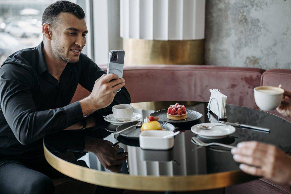 ilustrasi orang makan sambil menggunakan handphone (pexels.com/Pavel Danilyuk)